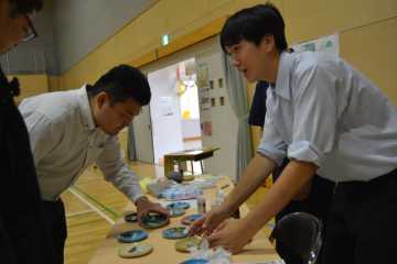札幌軟石にオイルを付けたアロマストーンを来場者にプレゼントする１年生