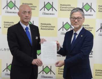 山城局長（左）が日野常務理事に要望書を手渡した